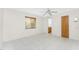 Well-lit bedroom featuring tile floors, a ceiling fan, and a window for natural light with view to bathroom at 3220 Peace River Dr, Punta Gorda, FL 33983