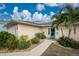 Inviting front entrance with lush landscaping and a vibrant teal door at 3220 Peace River Dr, Punta Gorda, FL 33983