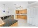 Bright kitchen with black countertops, wooden cabinetry, stainless steel appliances, and tiled floors at 3220 Peace River Dr, Punta Gorda, FL 33983