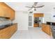 Spacious kitchen featuring tiled floors, wooden cabinets, stainless steel appliances, and black granite countertops at 3220 Peace River Dr, Punta Gorda, FL 33983