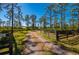 Driveway entrance to property with metal gate and wooden fence at 34775 Trails End Dr, Punta Gorda, FL 33982