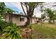Landscaped backyard with mature trees and a bird bath at 515 W Olympia Ave, Punta Gorda, FL 33950