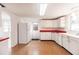 White kitchen cabinets, red countertops, and exterior access at 515 W Olympia Ave, Punta Gorda, FL 33950