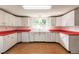 Retro kitchen with white cabinets and red countertops at 515 W Olympia Ave, Punta Gorda, FL 33950