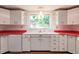 Kitchen with white cabinets and red countertops at 515 W Olympia Ave, Punta Gorda, FL 33950