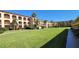 Beautiful condo building with a large green lawn and tropical landscaping at 1 Colony Point Dr # 16C, Punta Gorda, FL 33950