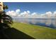 Enjoy this view of calm waters from the grassy lawn with lush landscaping and beautiful blue skies at 1 Colony Point Dr # 16C, Punta Gorda, FL 33950