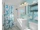 Bright bathroom with teal walls, starfish-themed shower curtain, and white vanity at 103 Salem Ave Nw, Port Charlotte, FL 33952