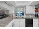 Kitchen with granite countertops, white cabinets, and a view of the canal at 18749 Ackerman Ave, Port Charlotte, FL 33948