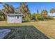 A backyard shed sits on a grassy lawn shaded by mature palm trees at 2387 Tamarind St, Port Charlotte, FL 33948
