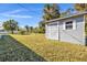 Backyard shed with light gray paint, one window, and a metal roof on a blue sky day at 2387 Tamarind St, Port Charlotte, FL 33948