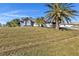 View of the home with a manicured lawn and mature palm trees at 2387 Tamarind St, Port Charlotte, FL 33948