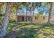 Spacious backyard with screened patio, lush landscaping, and palm trees at 267 Lecturn St, Port Charlotte, FL 33954
