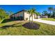 View of the home's side showcasing the garage and landscaping at 2696 Mather Ln, North Port, FL 34286