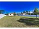 Large, grassy backyard enclosed by a white fence, offering privacy and space for recreation at 3393 Kacher Rd, North Port, FL 34288