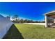 Spacious backyard featuring lush lawn, privacy fence, and a covered lanai area at 3393 Kacher Rd, North Port, FL 34288