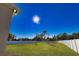 The expansive backyard is enclosed with a white privacy fence and has lush green grass at 3393 Kacher Rd, North Port, FL 34288