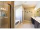 Bright bathroom featuring double vanity sinks, a soaking tub, and a glass enclosed shower at 3393 Kacher Rd, North Port, FL 34288