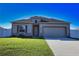 Beautiful single-story home with a well-manicured lawn, two-car garage, and stone accents near the entryway at 3393 Kacher Rd, North Port, FL 34288