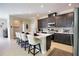 Stylish kitchen with an island, barstool seating, sleek countertops, dark cabinetry, and stainless steel appliances at 3393 Kacher Rd, North Port, FL 34288