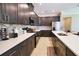Modern kitchen featuring dark cabinets, quartz countertops, stainless steel appliances, and a decorative tile backsplash at 3393 Kacher Rd, North Port, FL 34288
