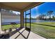 The screened-in lanai features a barbecue grill and a view of the green, fenced backyard at 3393 Kacher Rd, North Port, FL 34288
