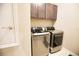 Laundry room with modern, stainless steel washer and dryer and overhead cabinets at 3393 Kacher Rd, North Port, FL 34288