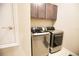 Modern laundry room with washer, dryer, and upper cabinets at 3393 Kacher Rd, North Port, FL 34288