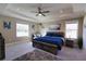 Spacious main bedroom featuring tray ceilings, a ceiling fan, two windows, carpeted floors, and neutral paint at 3393 Kacher Rd, North Port, FL 34288