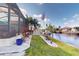 Landscaped canal-front yard with lush vegetation and a flag at 5247 Conner Ter, Port Charlotte, FL 33981