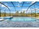 Screened-in pool with a spa and a view of the natural surroundings at 5640 Blue Reef Pl, Nokomis, FL 34275