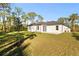 White house exterior with a large backyard and mature trees at 14059 Gailwood Ave, Port Charlotte, FL 33953