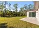 Spacious backyard with grassy lawn and sliding glass doors leading to the house at 14059 Gailwood Ave, Port Charlotte, FL 33953
