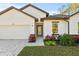 White house with brown roof, paver driveway, and landscaping at 14059 Gailwood Ave, Port Charlotte, FL 33953