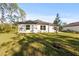Back exterior of a light-colored house with a grassy yard at 14059 Gailwood Ave, Port Charlotte, FL 33953