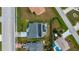 A bird's-eye view of a single-Gathering home with an enclosed pool, patio, and solar panels surrounded by lush landscaping at 19983 Midway Blvd, Port Charlotte, FL 33948