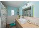 Coastal style bathroom with a colorful tropical shower curtain and light blue walls at 19983 Midway Blvd, Port Charlotte, FL 33948