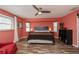 Bright bedroom with warm walls, ceiling fan, accent wall, and wood-look floors at 19983 Midway Blvd, Port Charlotte, FL 33948