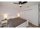 Well-lit bedroom with a ceiling fan, a white bed, nightstands, and closet doors at 19983 Midway Blvd, Port Charlotte, FL 33948