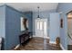 Welcoming foyer with wood-look flooring and stylish decor, wood panel wall, and console table at 19983 Midway Blvd, Port Charlotte, FL 33948