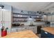 Kitchen featuring gray countertops, stainless steel appliances, wood breakfast bar, and open shelves at 19983 Midway Blvd, Port Charlotte, FL 33948