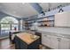 Modern kitchen featuring wood accents, stainless steel appliances, gray countertops, blue walls, and a breakfast bar at 19983 Midway Blvd, Port Charlotte, FL 33948