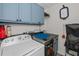Bright laundry room with blue cabinets, countertop space, washer, and dryer at 19983 Midway Blvd, Port Charlotte, FL 33948