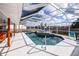 Inviting screened-in pool with a waterfall feature and plenty of space for relaxing under the sun at 19983 Midway Blvd, Port Charlotte, FL 33948