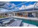 Beautiful screened-in pool area with solar panels, ample seating, and a clear view of the inviting pool at 19983 Midway Blvd, Port Charlotte, FL 33948