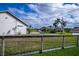 Green yard enclosed by a fence, showcasing the expansive outdoor area and neighborhood at 19983 Midway Blvd, Port Charlotte, FL 33948