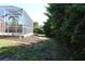 Backyard view of pool and patio with lush landscaping and mature trees at 3097 Royal Palm Dr, North Port, FL 34288