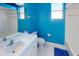 Bright blue bathroom with a modern white vanity, toilet, and a bathtub with a shower at 3097 Royal Palm Dr, North Port, FL 34288
