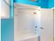 Bathroom featuring a tub with white tile surround and a blue accent wall, next to an open door at 3097 Royal Palm Dr, North Port, FL 34288