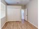 Well-lit bedroom features hardwood floors, a large closet, and a doorway to another room at 3097 Royal Palm Dr, North Port, FL 34288